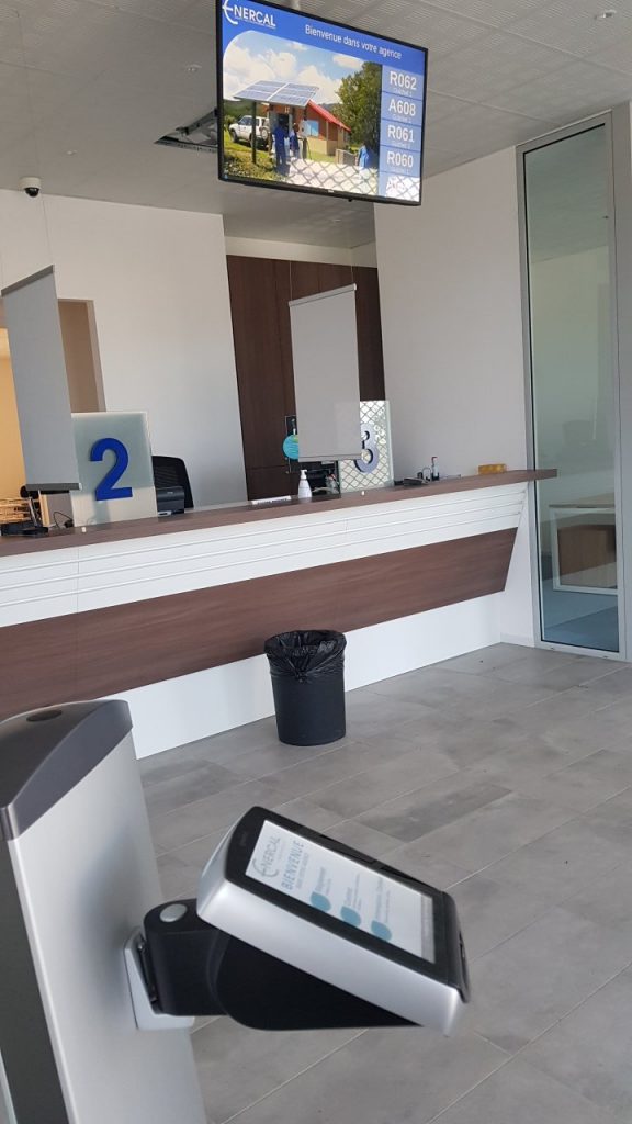 Écran d'affichage dynamique et borne Qmatic à l'accueil de l'agence Enercal de Koné