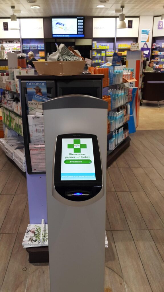 Borne de prise de ticket Qmatic à la Pharmacie de la Place