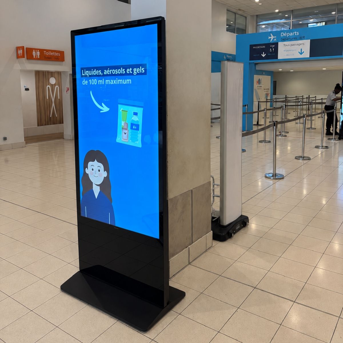 Totem Philips affichant les règles sur les liquides et gels en cabine à La Tontouta