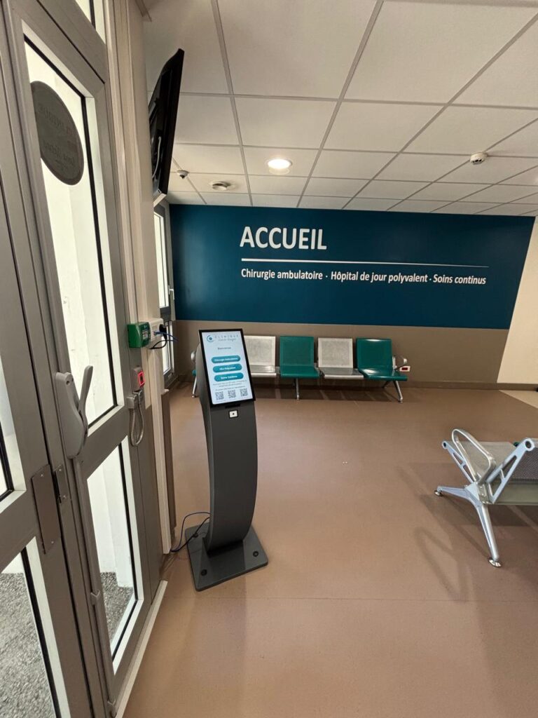 Borne à tickets Voyager de VisualCom dans le hall d'accueil de la Clinique Kuindo-Magnin, avec choix du service